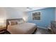 Serene bedroom featuring blue accent wall, ceiling fan, and cozy decor at 2560 Sunnyside St, Sarasota, FL 34239