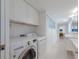 Convenient laundry area with modern washer and dryer, adjacent to a bright bathroom for added functionality at 2560 Sunnyside St, Sarasota, FL 34239