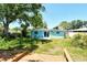 The backyard features a patio and deck amid tropical trees at 305 Palmetto W Rd, Nokomis, FL 34275