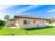 Back exterior view featuring a well-maintained lawn and showing an air conditioning unit with an entrance to the property at 3213 Cambridge Ave, Bradenton, FL 34207