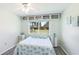 Bright bedroom features a window view, ceiling fan, updated floors, and turtle quilt at 3213 Cambridge Ave, Bradenton, FL 34207