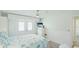 Bright bedroom featuring white wainscoting, ceiling fan, French doors and beach themed quilt at 3213 Cambridge Ave, Bradenton, FL 34207