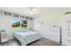 Bright bedroom features a window view, ceiling fan, updated floors, and turtle quilt at 3213 Cambridge Ave, Bradenton, FL 34207