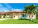 Beautiful home with a terracotta roof, a covered carport, and inviting blue Adirondack chairs on the front porch at 3213 Cambridge Ave, Bradenton, FL 34207