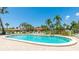 Outdoor pool surrounded by palm trees and lounge chairs, perfect for relaxation at 3213 Cambridge Ave, Bradenton, FL 34207