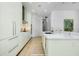 Open kitchen design featuring island with sink, sleek white cabinetry, and stainless appliances at 33 S Palm Ave # 1602, Sarasota, FL 34236