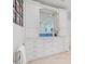 Bright bathroom features a vanity with white cabinets, drawers, and a framed mirror at 3300 Casey Key Rd, Nokomis, FL 34275