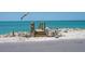 Beach access via wooden steps with railing, leading down to sandy shores and turquoise waters at 3300 Casey Key Rd, Nokomis, FL 34275