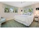 Bright bedroom with large bed, decorative pillows, and sunlit windows with lush views at 3300 Casey Key Rd, Nokomis, FL 34275