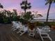 Wooden deck furnished with chairs featuring waterfront views at 3300 Casey Key Rd, Nokomis, FL 34275