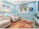 Sitting room with tan furniture, blue walls, terracotta tile flooring, and nautical decor at 3300 Casey Key Rd, Nokomis, FL 34275