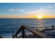 Sunset view from beach access steps, featuring clear skies and shimmering ocean water at 3300 Casey Key Rd, Nokomis, FL 34275