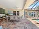 Outdoor dining area on the patio with a ceiling fan and tiled floors next to pool at 3300 Casey Key Rd, Nokomis, FL 34275