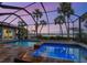 Backyard pool and spa with a screened enclosure offering serene waterfront views at 3300 Casey Key Rd, Nokomis, FL 34275