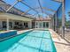 An inviting screened pool area with tile, with views of the house and its backyard at 3300 Casey Key Rd, Nokomis, FL 34275