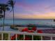 Scenic water view from balcony showing palm trees and vibrant sunset at 3300 Casey Key Rd, Nokomis, FL 34275