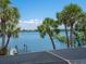 Scenic water view featuring a dock with boat lift and palm trees on a sunny day at 3300 Casey Key Rd, Nokomis, FL 34275