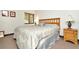 Cozy bedroom features a queen bed with neutral bedding, and a wooden nightstand at 36750 Us 19 N # 03102, Palm Harbor, FL 34684