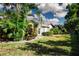 Lush backyard featuring beautiful landscaping, mature trees, and a well-maintained lawn at 3843 El Poinier W Ct # 8720, Sarasota, FL 34232