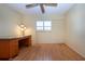 Sun-lit bedroom featuring hardwood floors, a ceiling fan, and a classic wooden desk at 3843 El Poinier W Ct # 8720, Sarasota, FL 34232