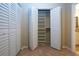 Open closet with shelving, and floor-to-ceiling closet with bifold doors, tiled floor and adjacent bathroom at 3843 El Poinier W Ct # 8720, Sarasota, FL 34232