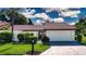 Charming single-story home featuring a lush, green lawn and well-maintained landscaping at 3843 El Poinier W Ct # 8720, Sarasota, FL 34232