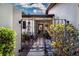 Inviting courtyard entrance with decorative gate and lush landscaping, leading to the home at 3843 El Poinier W Ct # 8720, Sarasota, FL 34232