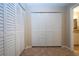 Hallway featuring floor-to-ceiling closet with bifold doors, tiled floor and adjacent bathroom at 3843 El Poinier W Ct # 8720, Sarasota, FL 34232