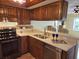 Well-appointed kitchen with stainless steel appliances, wood cabinets, and breakfast bar at 3843 El Poinier W Ct # 8720, Sarasota, FL 34232