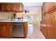 Bright kitchen with stainless steel dishwasher, warm wood cabinetry, and tile flooring at 3843 El Poinier W Ct # 8720, Sarasota, FL 34232