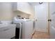 This laundry room boasts lots of cabinet space, a utility sink, and a convenient washer and dryer at 3843 El Poinier W Ct # 8720, Sarasota, FL 34232