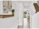Bright hallway with tile flooring, complemented by neutral wall art, a decorative shelf, and stairs on the right at 4073 Gold Dust Ln, Sarasota, FL 34243