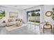 Bright living room with neutral tones, tile flooring, and sliding glass doors to the backyard at 4073 Gold Dust Ln, Sarasota, FL 34243