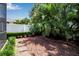 This backyard has rock landscaping, stepping stones, green hedges, and a privacy fence perfect for outdoor activities at 4706 Josselin Pl, Parrish, FL 34219