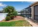 Landscaped backyard featuring a well-maintained lawn, tropical plants, and a screened enclosure for the pool area at 4706 Josselin Pl, Parrish, FL 34219