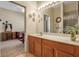 Bathroom with double sink vanity and a view to an adjacent bedroom with a decorative desk at 4706 Josselin Pl, Parrish, FL 34219
