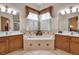 Inviting bathroom features a soaking tub framed by dual vanities and charming window treatments at 4706 Josselin Pl, Parrish, FL 34219