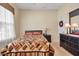 Well-lit bedroom with a decorative quilt, window with blinds, and a dark wood dresser at 4706 Josselin Pl, Parrish, FL 34219
