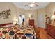 Spacious bedroom with wooden floors, quilt, and bathroom access at 4706 Josselin Pl, Parrish, FL 34219