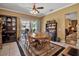 Dining room with ceiling fan, table, chairs, china cabinet, and sliding glass doors to pool at 4706 Josselin Pl, Parrish, FL 34219