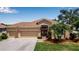 Exterior of a well-maintained single-Gathering home with a three-car garage, mature landscaping, and a manicured lawn at 4706 Josselin Pl, Parrish, FL 34219