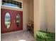 Elegant double front doors with decorative glass, complemented by a small side table and lush landscaping at 4706 Josselin Pl, Parrish, FL 34219
