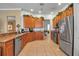 Spacious kitchen featuring stainless steel appliances, tile floors, and wooden cabinets with granite countertops at 4706 Josselin Pl, Parrish, FL 34219