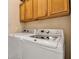 Well-equipped laundry room with modern washer and dryer, practical cabinet space, and neutral decor at 4706 Josselin Pl, Parrish, FL 34219