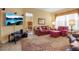 Comfortable living room with a floral rug, red seating, and mounted TV at 4706 Josselin Pl, Parrish, FL 34219