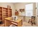 Bright office space with large desk, shelving, and natural light from a window at 4706 Josselin Pl, Parrish, FL 34219