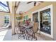 This covered patio features a ceiling fan, flat screen television, an outdoor dining set, and access to the screened-in pool at 4706 Josselin Pl, Parrish, FL 34219