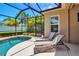 Relax in this pool area with sun loungers, a clear view of the pool, and a well-manicured landscape outside the screened enclosure at 4706 Josselin Pl, Parrish, FL 34219