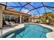 Relax in this large pool with sun loungers while enjoying the lush, manicured backyard within the screened-in enclosure at 4706 Josselin Pl, Parrish, FL 34219