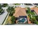 Aerial view of a beautiful pool with a fountain feature inside a screened enclosure and a well-manicured backyard at 4706 Josselin Pl, Parrish, FL 34219
